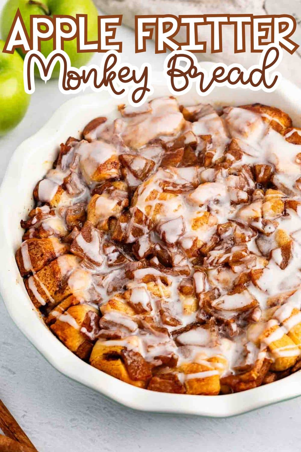 A round dish filled with apple fritter monkey bread, topped with white icing drizzle. The dessert has chunks of bread and visible cinnamon. Text at the top reads Apple Fritter Monkey Bread.