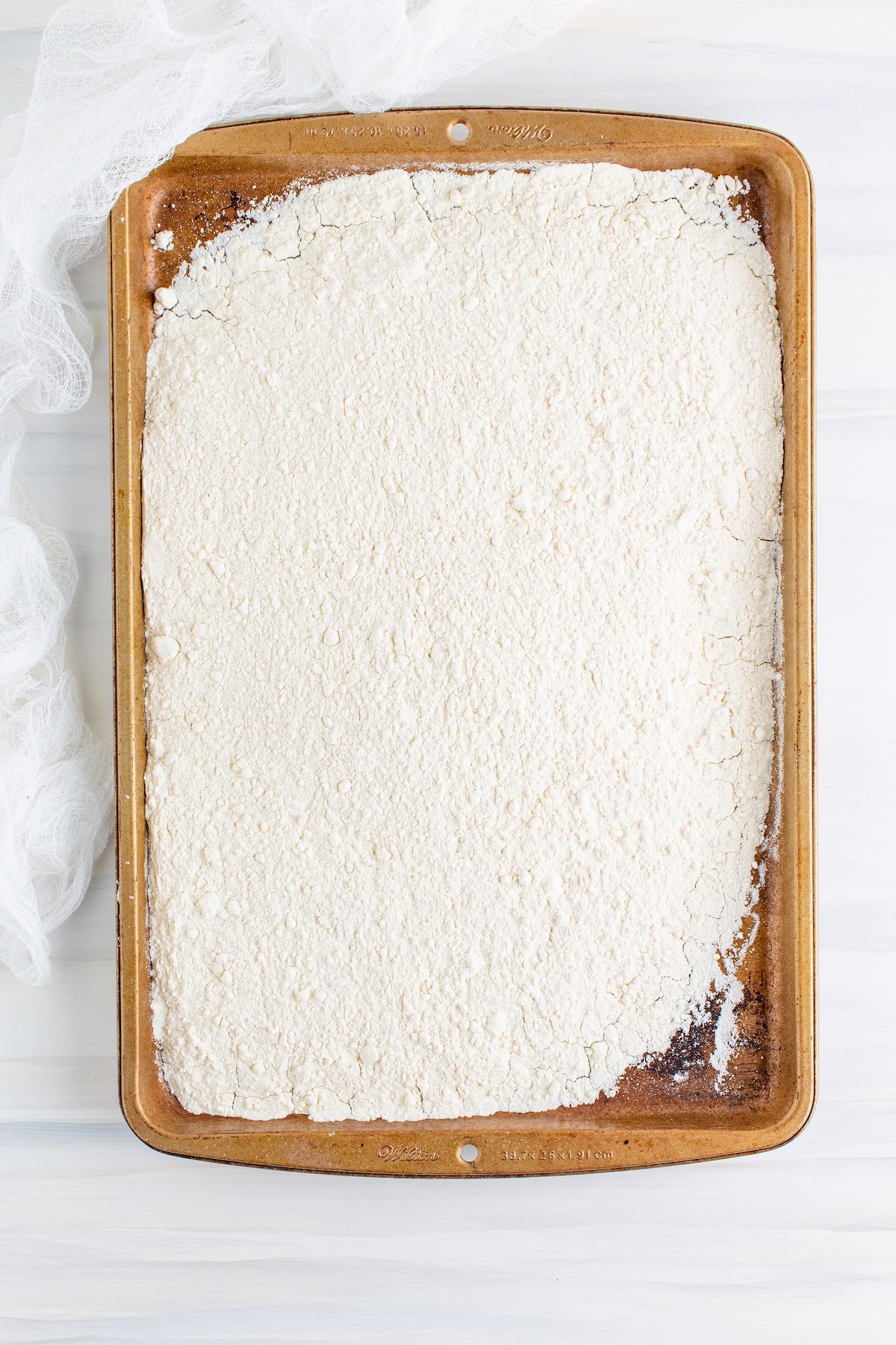Overhead shot of flour spread out on a baking sheet