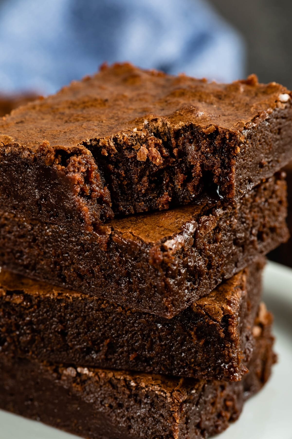 stacked brownies on a white plate.