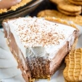 one slice of cream pie on a grey plate next to a nutter butter cookie