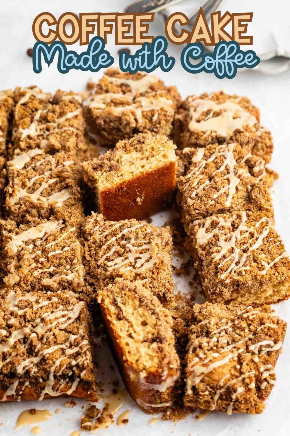 A sliced coffee cake topped with a crumbly streusel and drizzled icing, arranged on parchment paper. Text above reads, Coffee Cake Made with Coffee.