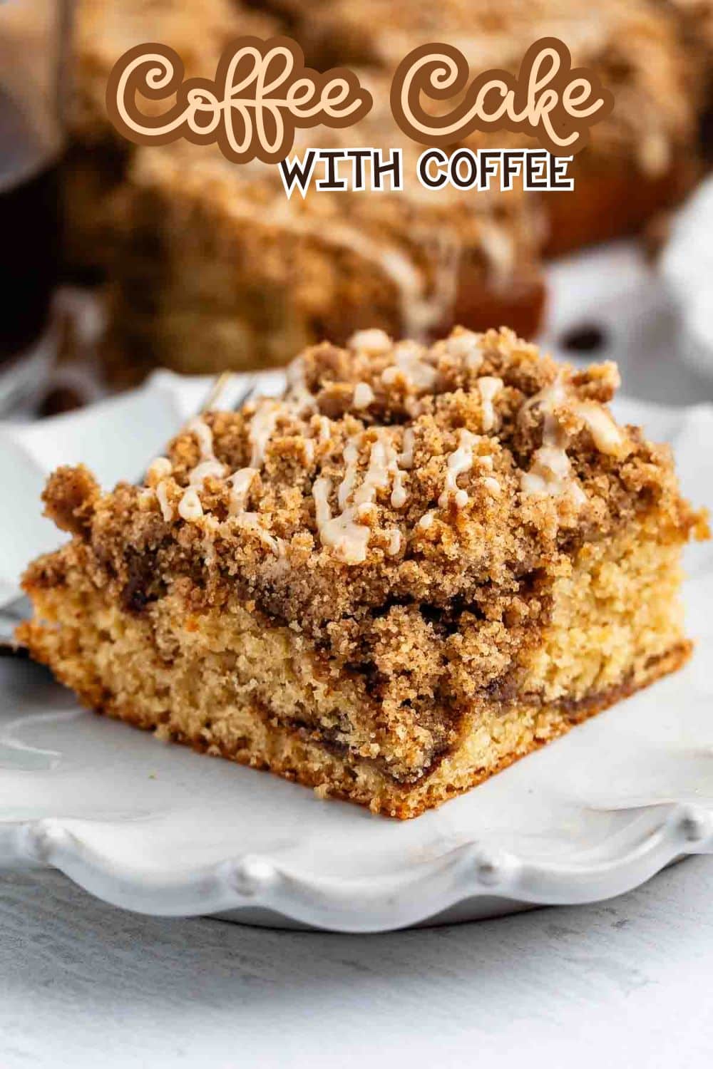 A slice of coffee cake with a crumbly cinnamon streusel topping and icing drizzle sits on a decorative white plate. Text above reads Coffee Cake with Coffee.