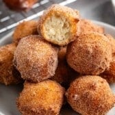 stacked donut holes on a grey plate.