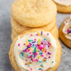 sugar cookie with white frosting and pink and blue sprinkles.