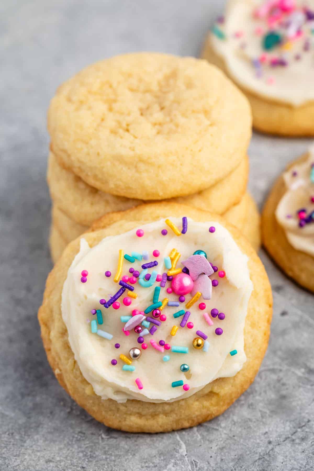 sugar cookie with white frosting and pink and blue sprinkles.