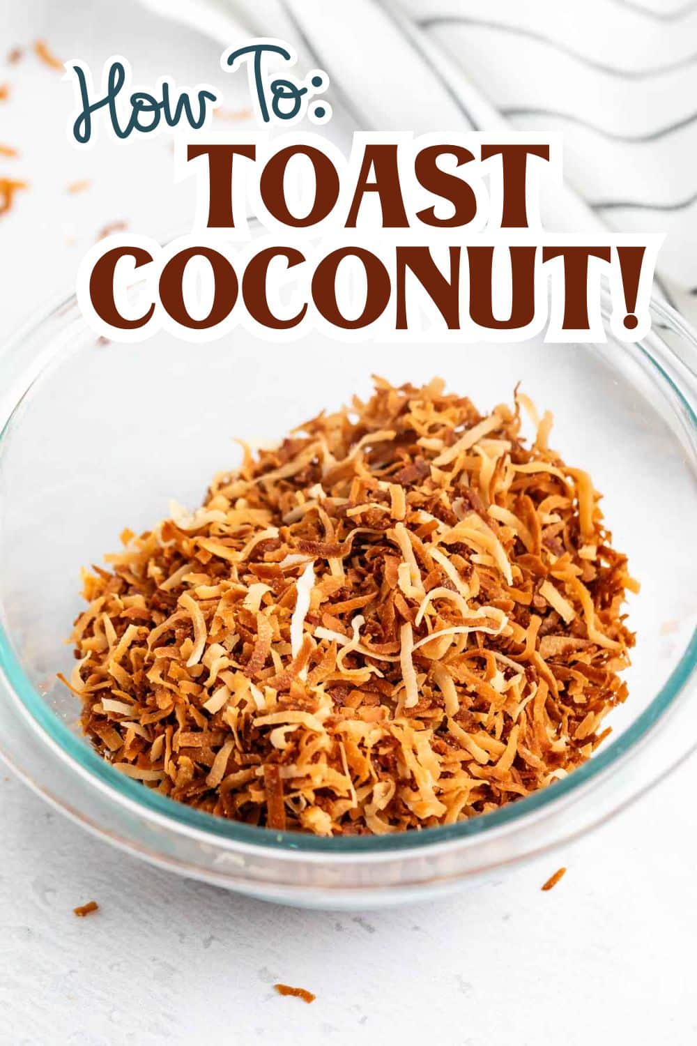 A glass bowl filled with toasted shredded coconut sits on a white surface. The text above reads, How To: Toast Coconut! in bold, decorative fonts.