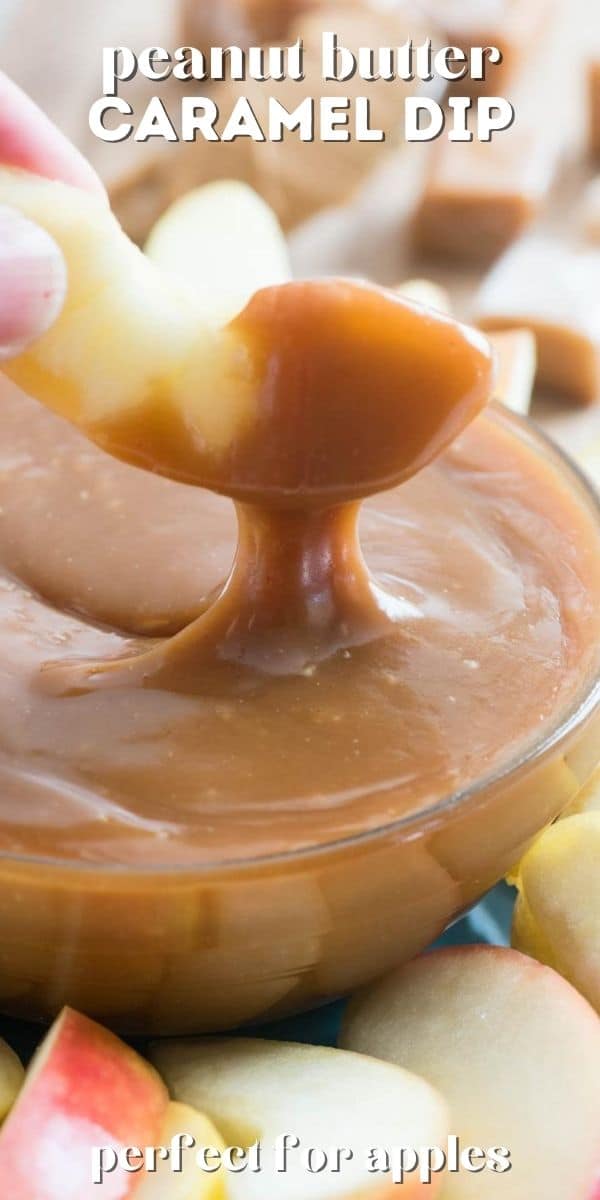 hand dipping apple in caramel